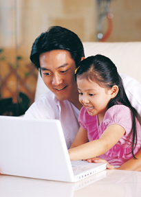 Dad and daughter at laptop computer