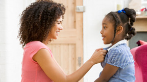 Mom dressing daughter