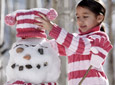 A girl building a snowman.